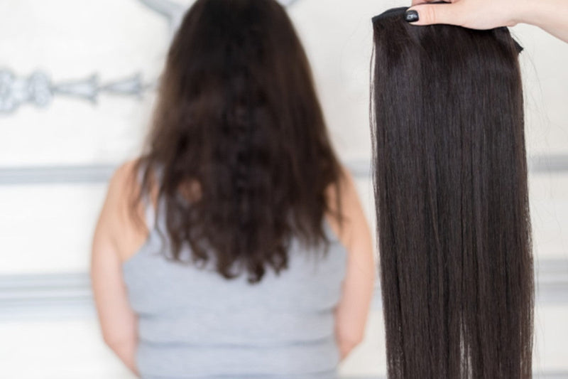 A short woman next to long hair extensions.