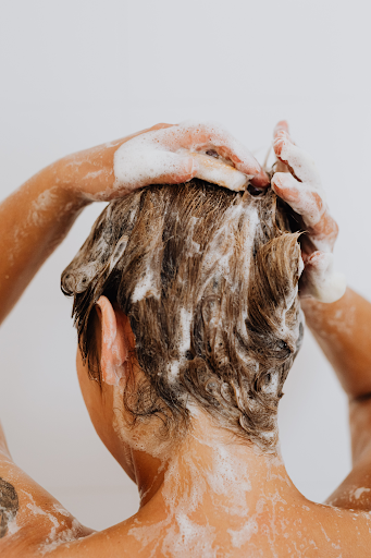 Image of a woman in the shower whilst washing her hair.