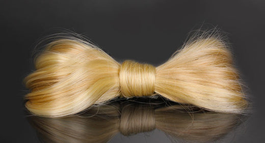 A blonde human hair extension tied into a bow