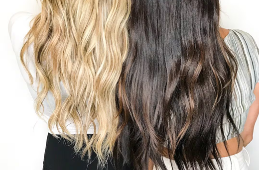 A blonde and brunette woman—both with long hair cascading—stood next to each other.