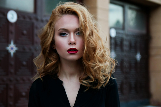A young woman with short and voluminous strawberry-blonde hair.