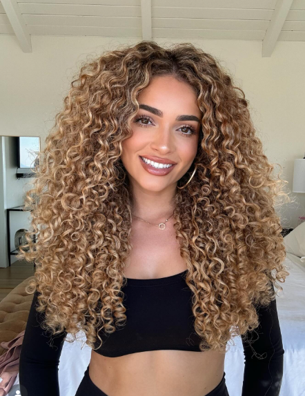 Image of a girl with long curly hair extensions.