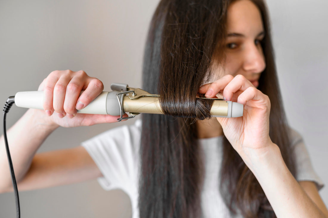 Image of a girl curling her hair topper with a curling wand.