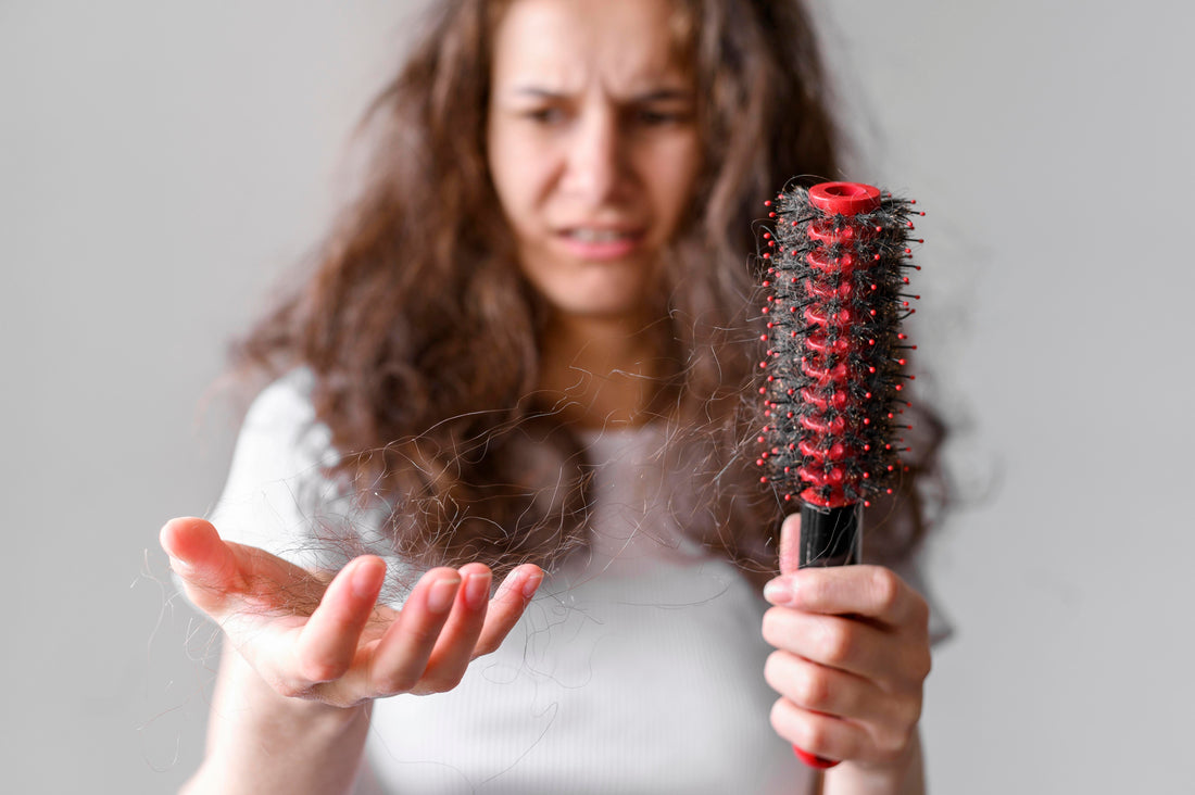 Image of a girl with long hair looking at her hair brush.