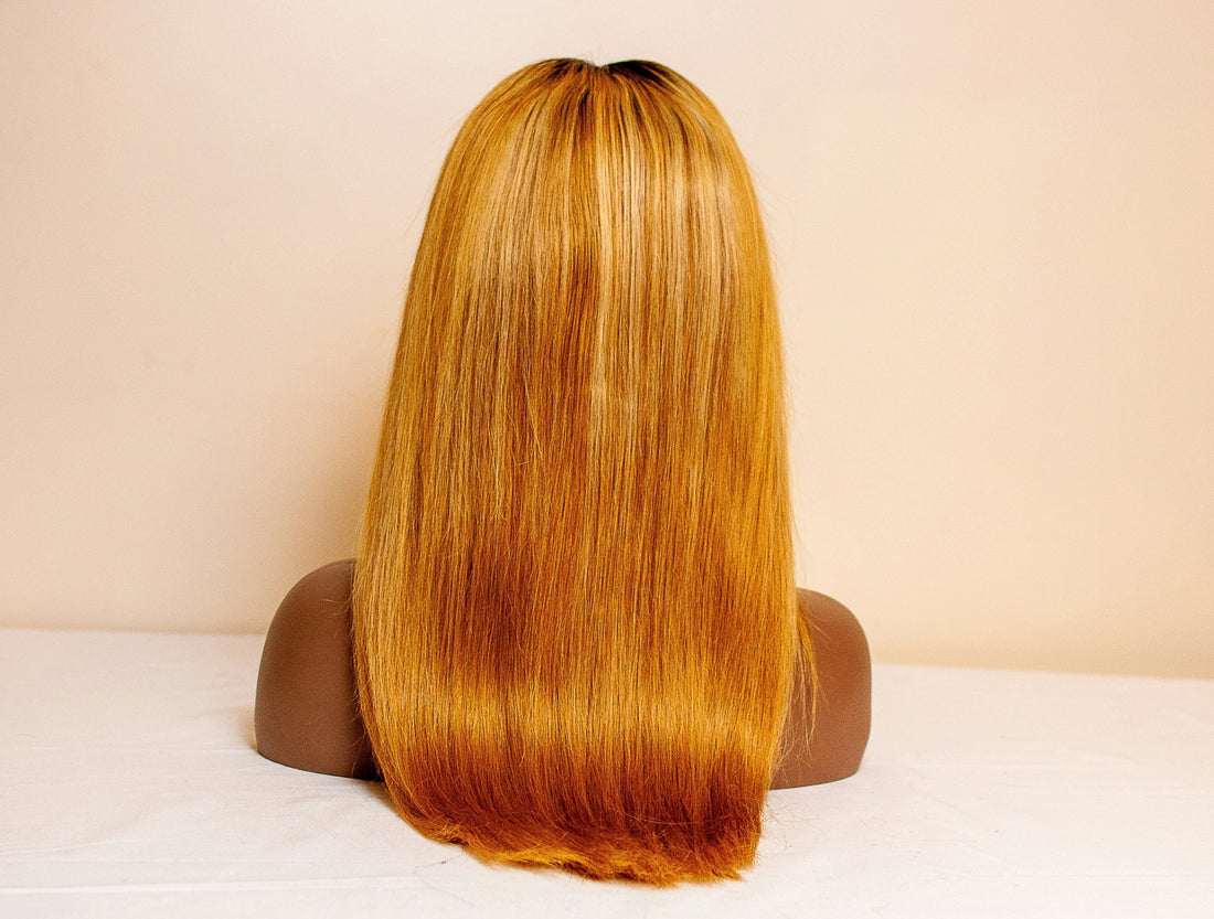 Image of a long, orange wig from behind.