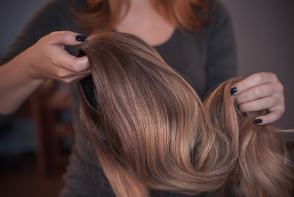 Women holding a brunette wig