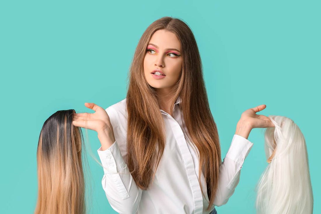 A woman holding two wigs of different colors