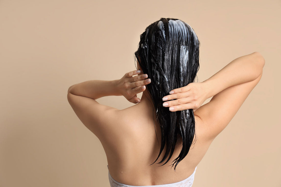 A woman applying a hair mask.