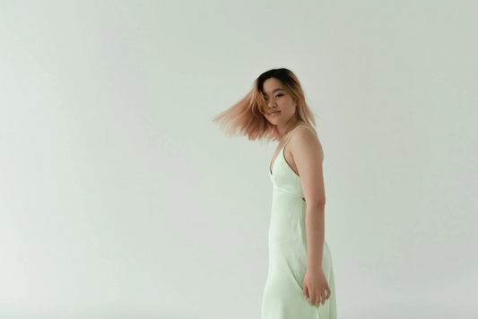 A woman turning her head and her hair, dyed in a milk-tea shade, swaying.