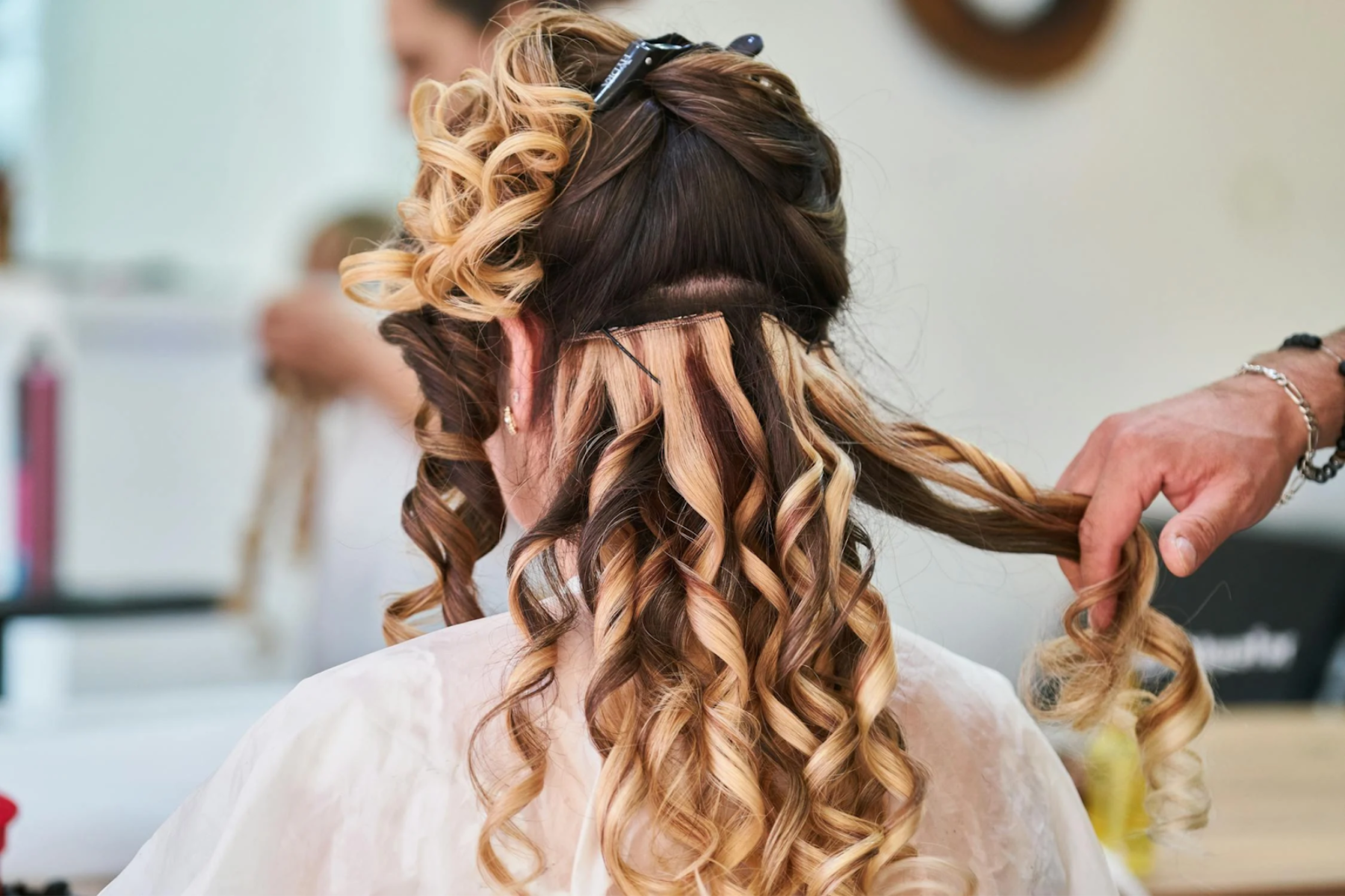 Image of a girl with hair extensions in, having her hair cut with layers. Taken from Pexels