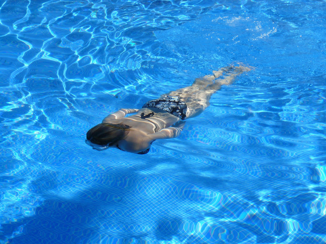 Image of a girl in the pool swimming. Taken from Pexels