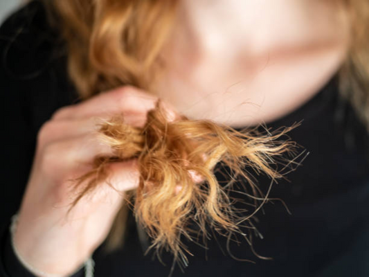 A ginger-haired girl holds her hair close to the camera to zoom on. Source: iStock