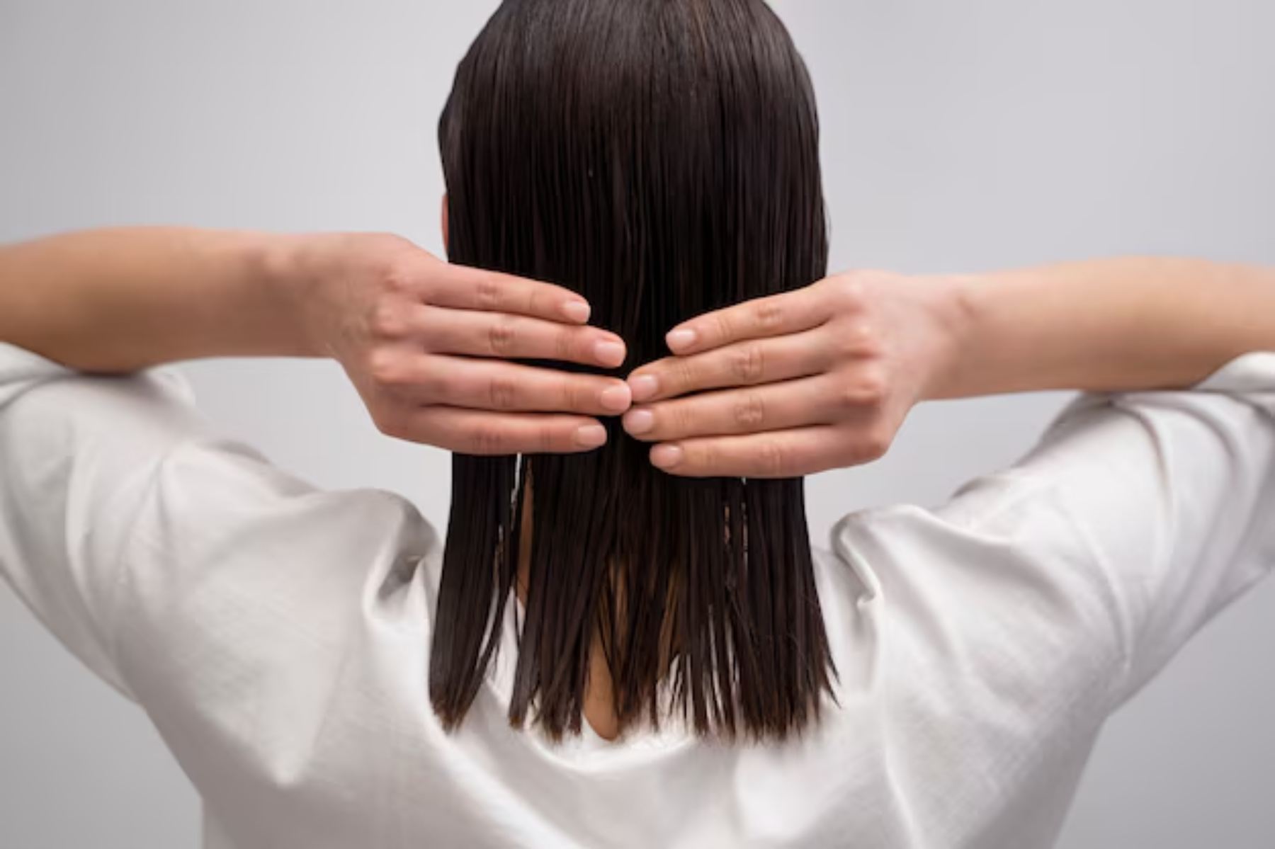 A short-haired lady with a Brazilian blowout touching her hair from the back. Source: Freepik