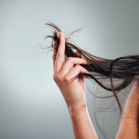 Image of a woman holding the ends of her hair. Taken from iStock