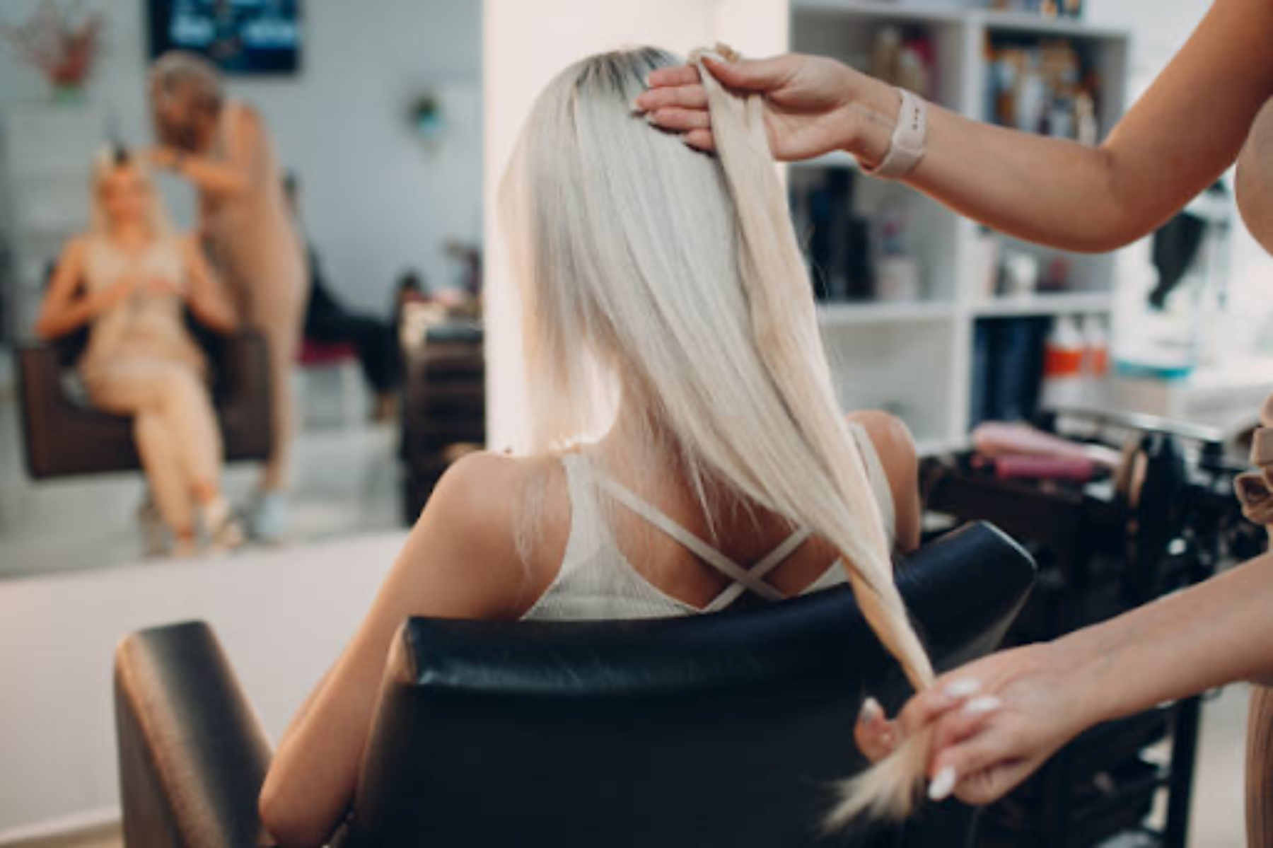 Image of a lady in a chair getting hair extensions. Taken from iStockPhoto