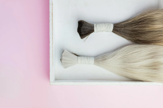 A pair of blonde and brunette hair extensions on a tray.