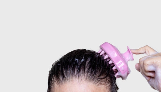 Photo of woman using scalp massager to shampoo hair