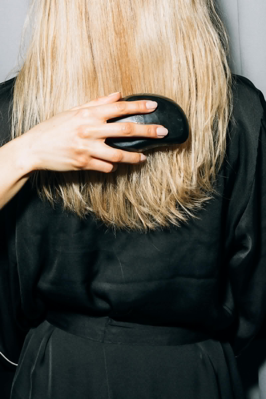 Image of a lady using a tangle teezer on blonde hair.