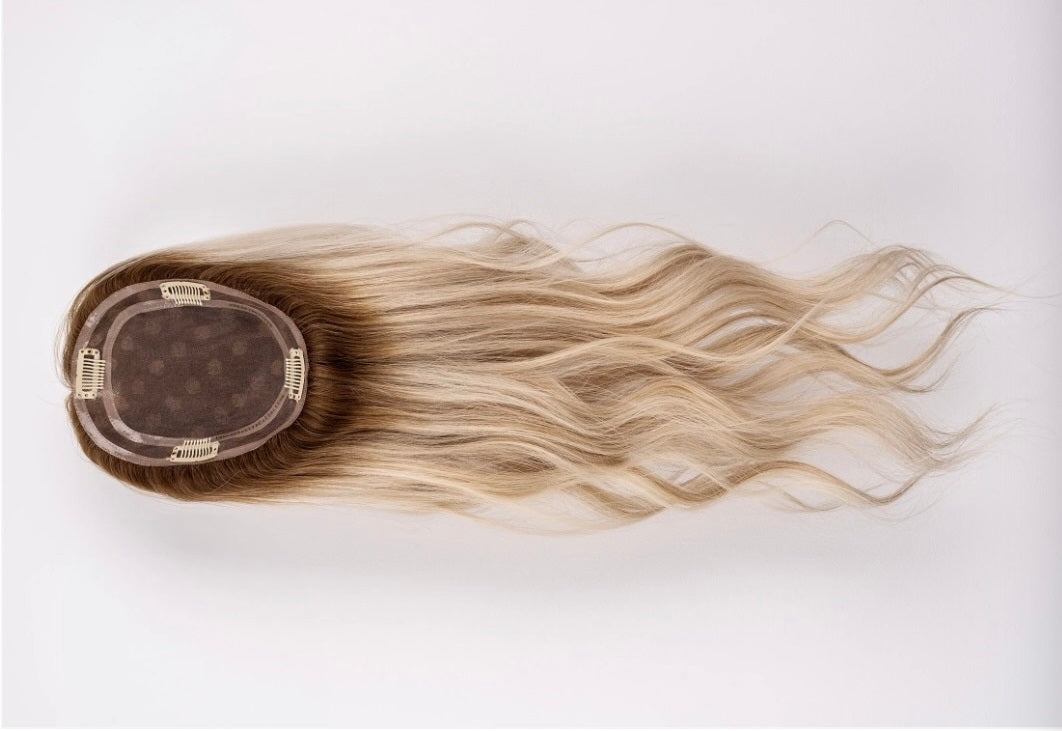 A long blonde light volume hair topper.