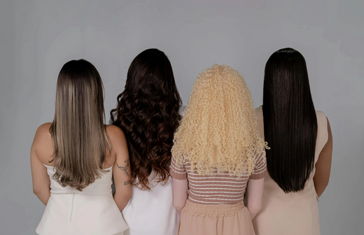 A group of four women with different hair colors and textures wearing long extensions.