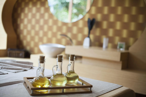 Image of three bottles of oil on a tray against a bathroom backdrop.