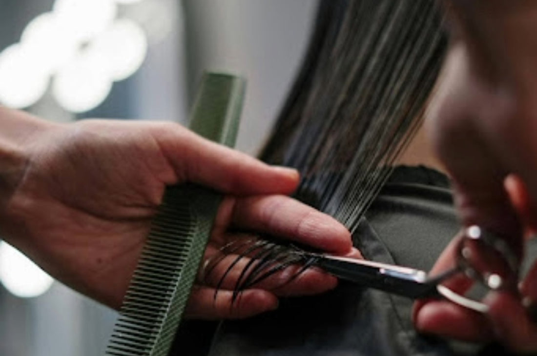 Close up view of a hand cutting the hair of a woman. Source: Pexels