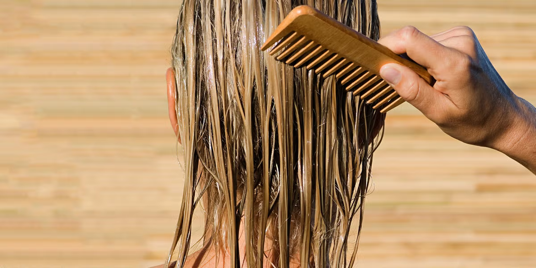 Image of a girl brushing her hair with a comb. 