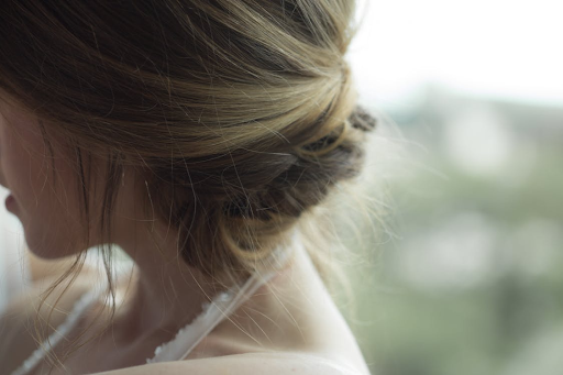 A close-up shot of a woman with a messy bun updo.
