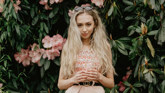 Photo by Alasdair Braxton/Pexels of woman standing against flowers