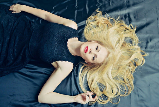 Image by 705326 from Pixabay of a blonde woman lying in bed with hair spread across sheets