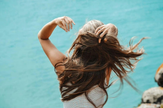 Photo by Helena/Pexels of Back view photo of woman in white sleeveless shirt running her fingers through her hair