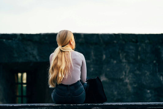 Photo by Omar Ram on Unsplash of woman sitting with long ponytail