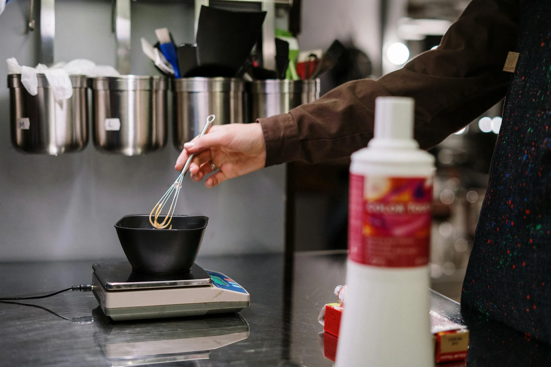 A person using a whisk to mix hair dye.