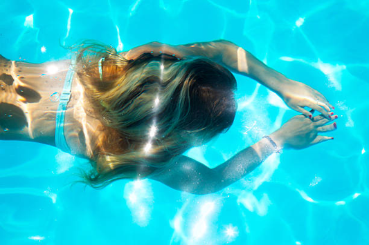 Image of a girl with blonde hair swimming in the water.