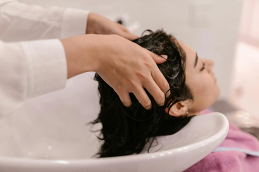 A woman having her hair washed in a hair salon.