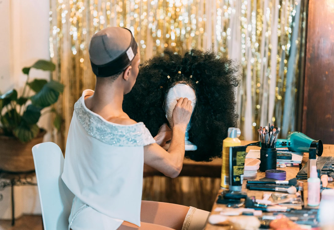 A woman prepping her Afro-style wig.